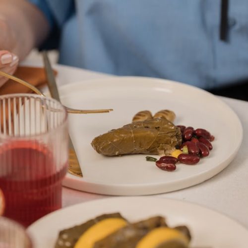 A close-up shot of dolma served with beans and colorful salad, captured during a meal.