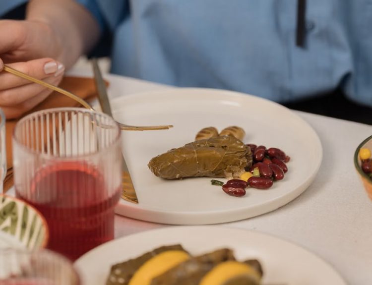 A close-up shot of dolma served with beans and colorful salad, captured during a meal.