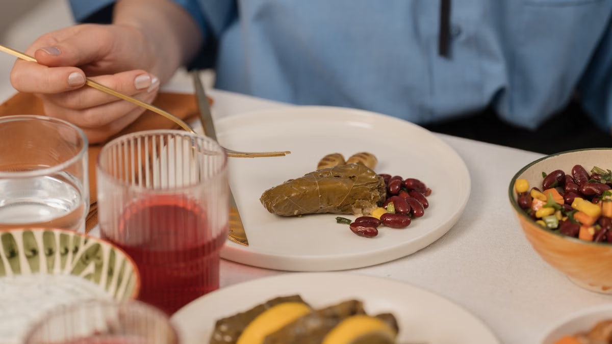 A close-up shot of dolma served with beans and colorful salad, captured during a meal.